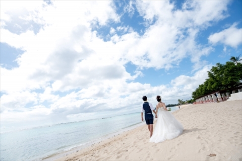 ハワイの海辺で結婚式を挙げる新郎新婦